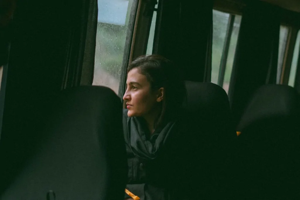 Kobieta patrzy przez okno autobusu w czasie podróży