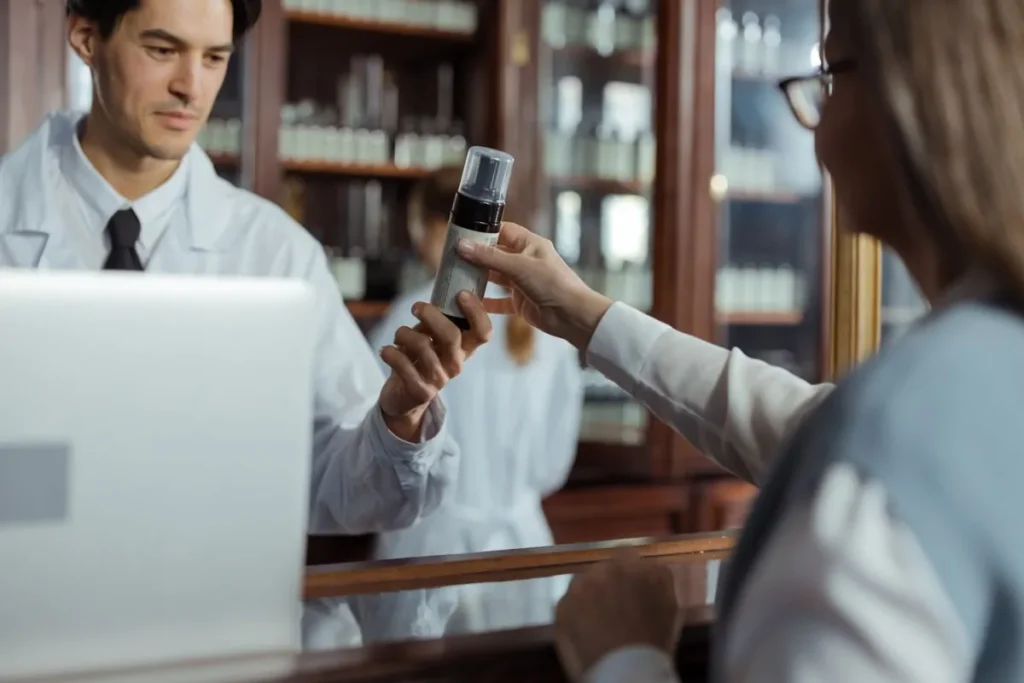 Farmaceuta podaje lek klientce w aptece
