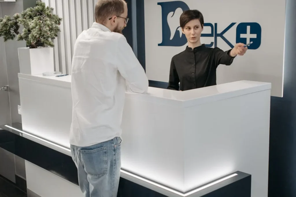 Kobieta przy okienku w urzędzie obsługuje interesanta
